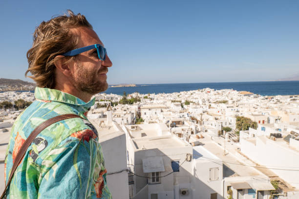 istock Young man contemplates Mykonos town from above 1361764369