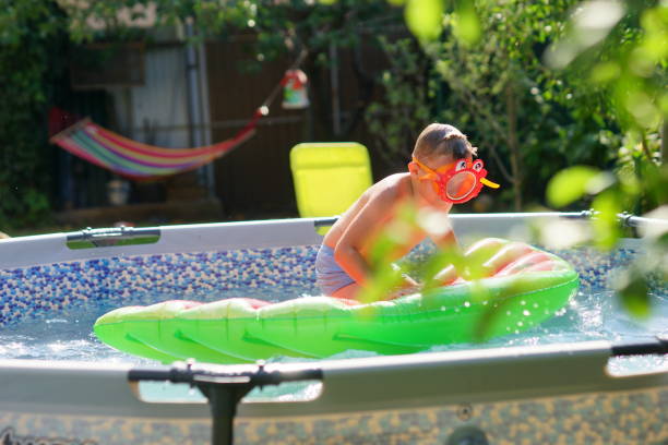 istock Boy in a swimming pool. Summer refreshing procedure. Cool time. Happy moments. 1361773230