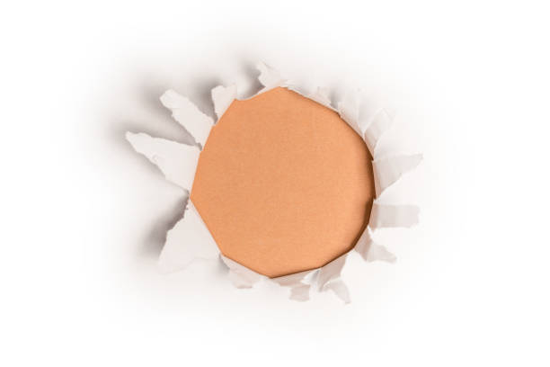 istock A hole in a white paper on an orange background 1361775254