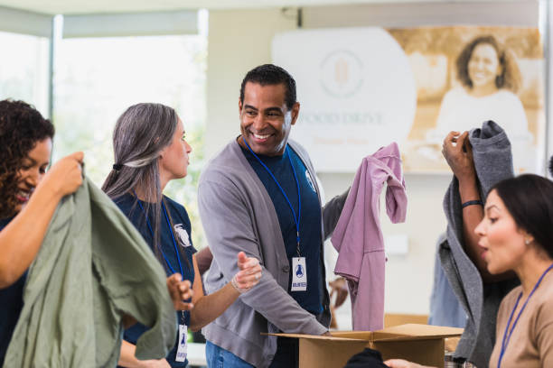 istock Cheerful man volunteers during clothing drive 1361776621