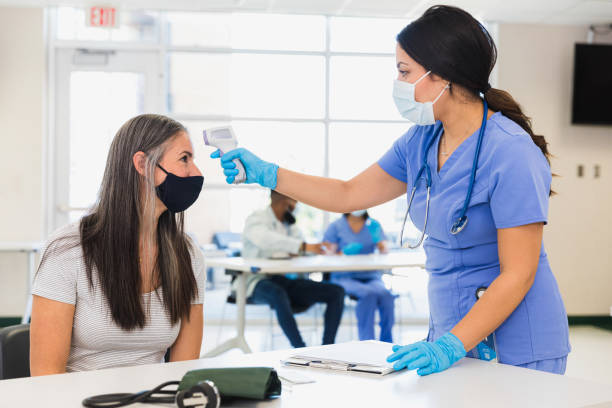 istock Volunteer nurse takes patient's temperature 1361776623