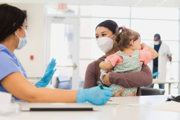 istock Mother holds baby as nurse explains procedure 1361776872