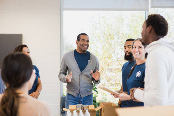 istock Diverse volunteers smile and talk before working on food drive 1361776885