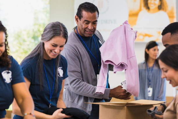 istock Mature male volunteer sorting through clothing donations 1361777335