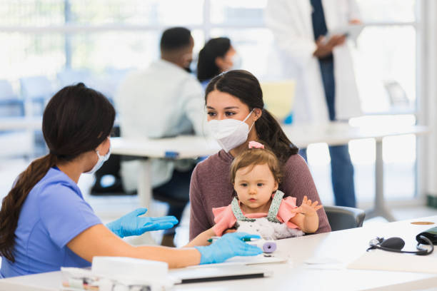 istock Young mother listens as nurse discusses baby's symptoms 1361778542