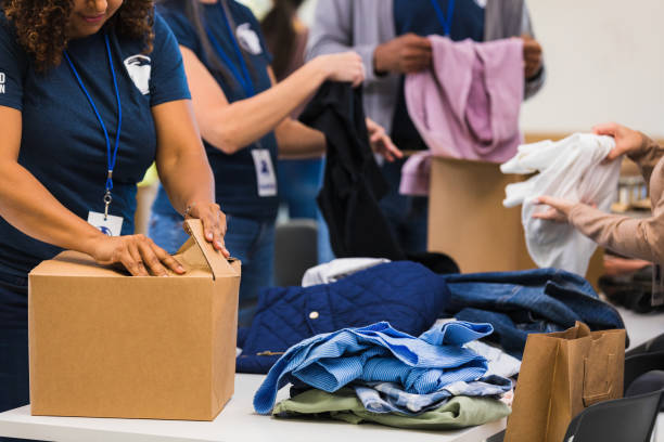 istock Unrecognizable adults sort and box donated clothing 1361778788