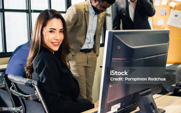 Beautiful Smart Asian Businesswoman Wearing Dress Smiling With Happiness And Success Using Laptop For Working And Networking Looking At Camera Sitting On Desk In Modern Indoor Office Business Concept Stock Photo - Download Image Now