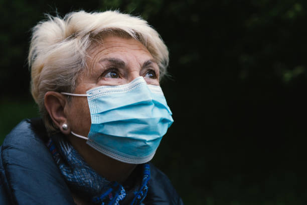 ritratto di donna anziana con maschera blu - idealist foto e immagini stock