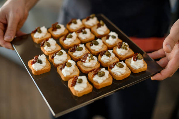 istock Close-up view on small delicious appetizing bruschettas on a tray in male hands 1361781939