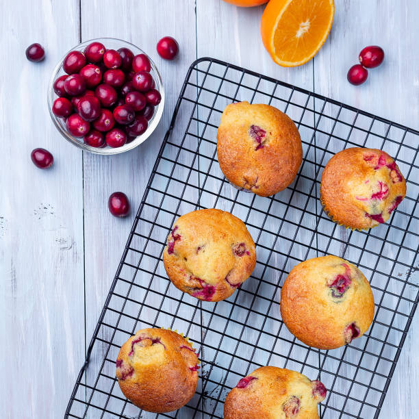 istock Homemade cranberry orange muffins on cooling rack, top view, square format 1361782723