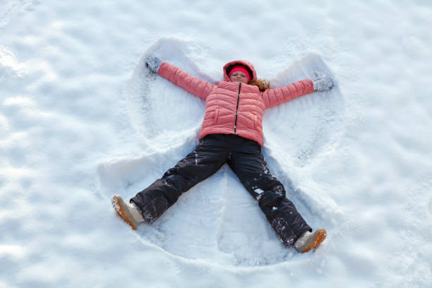 istock Girl making snow angel 1361789317