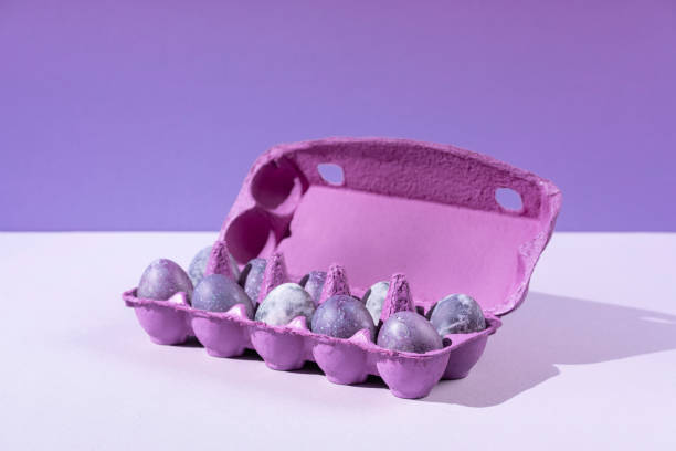 istock Purple egg packaging with eggs on blue background. Festive Easter concert with hard shadows. 1361790366