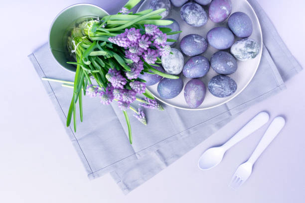 istock Top view of blue painted Easter eggs on a plate and spring flowers. blured foreground. 1361790408