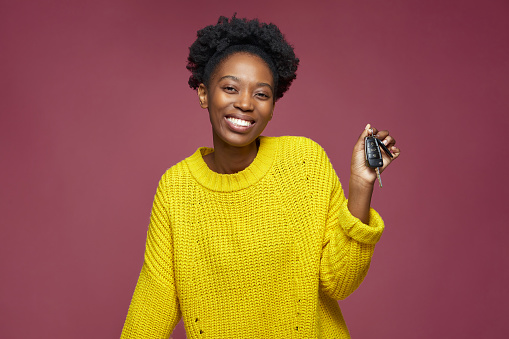 Joyful african american young woman holding car keys. Excited successful female winner showing automobile key. Lucky buying. High quality photo