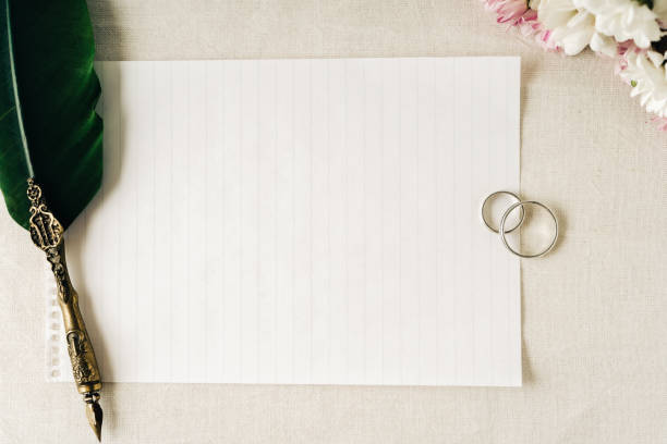 istock Some wedding or engagement rings along with an old pen and paper to write a note. Beautiful flowers accompany the composition. 1361794743