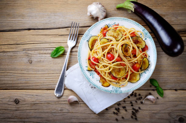 istock Spaghetti with eggplant and cherry tomatoes, top view, space for text, flat lay. 1361797505