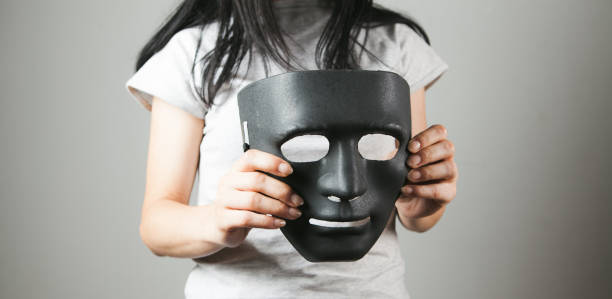 istock woman holding black anonymous mask 1361802820