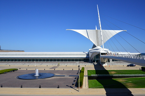 Milwaukee, Wisconsin, USA: Reiman Pedestrian Bridge aka Milwaukee Art Museum Pedestrian Bridge, a cable-stayed footbridge with semi-fan system leading to the Quadracci Pavilion of the Milwaukee Art Museum (MAM) with its iconic Burke brise soleil, spanning Lincoln Memorial Drive and Cudahy Gardens - architect Santiago Calatrava.