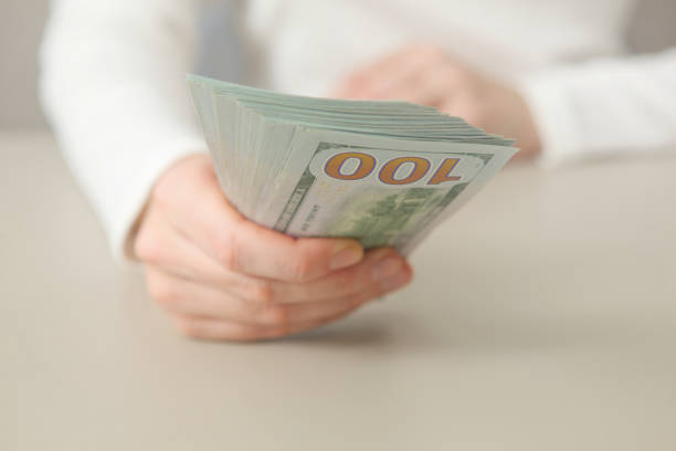 istock Many dollar bills in female hands close up 1361803898