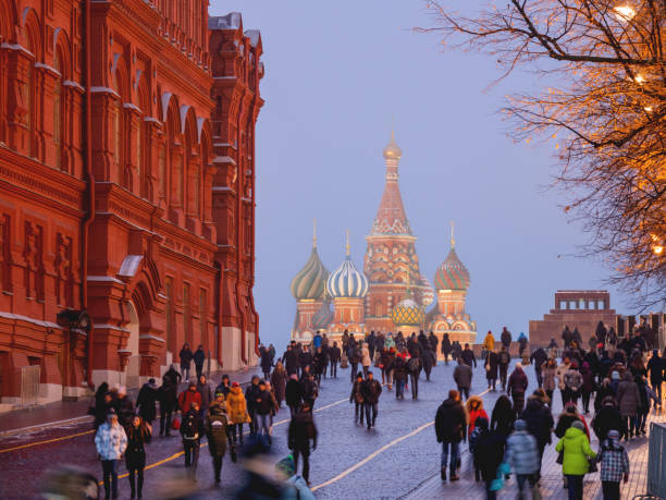 People are walking pass State Historical Museum to Saint Basil's Cathedral on Red square. stock photo