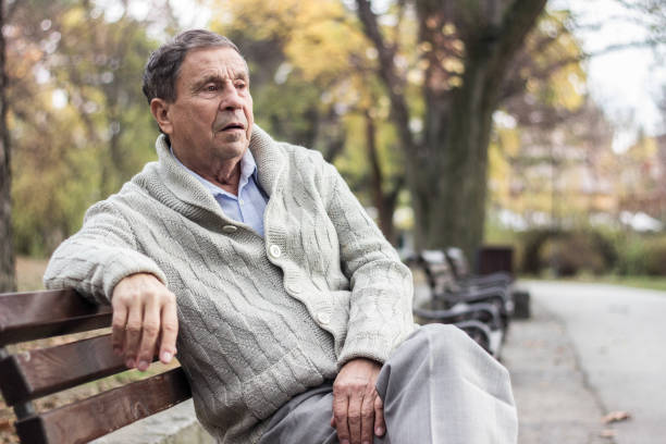 istock Senior man sitting on bench in the park 1361806512