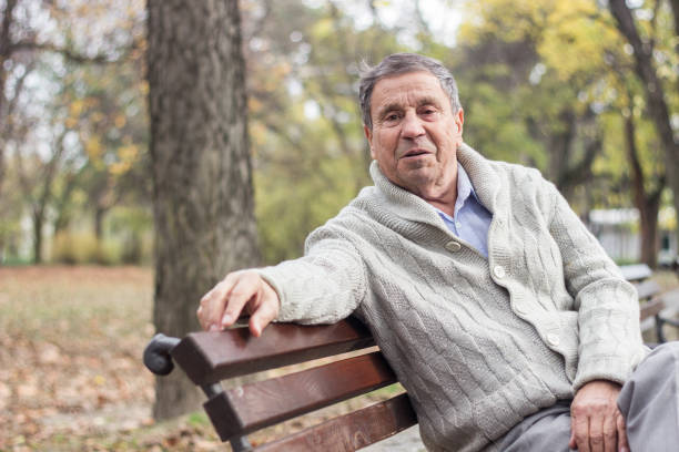 istock Senior man sitting on bench in the park 1361806513