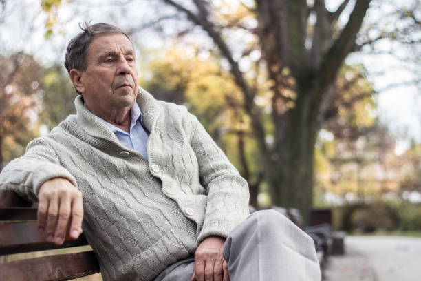istock Senior man sitting on bench in the park 1361806515
