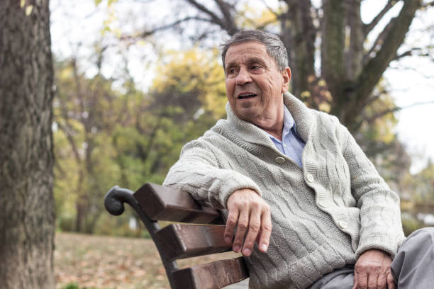 istock Senior man sitting on bench in the park 1361806820