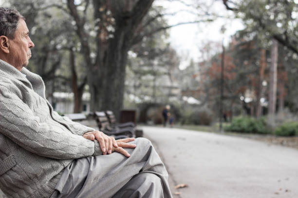 istock Senior man sitting on bench in the park 1361807391