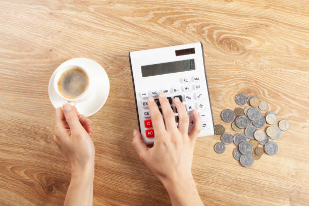 istock woman counts on a calculator and drinks coffee 1361808257