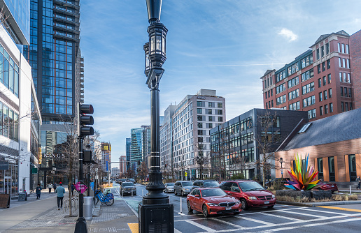 Boston Massachusetts, United States - December 28, 2021: Relaxing view of the boulevard de Seaport, with its modern businesses, on a sunny winter morning. The Seaport District is a remodeled stretch of the South Boston Boardwalk lined with large and elegant restaurants, bars, and hotels.