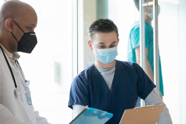 istock Surgeon and nurse reading medical chart 1361814011
