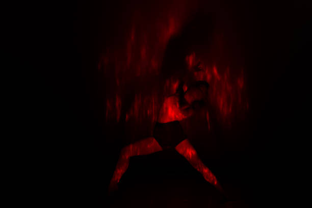 istock Beautiful dancer moving her body in front of and red light while performing a perfect dance composition of moves. The dance scene is showing off the inferno in a spectacular way. 1361815156