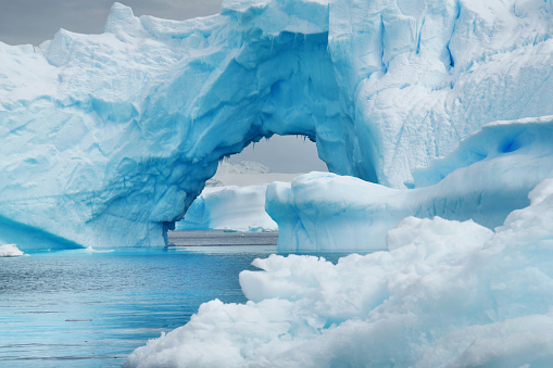 Blue ice occurs when snow falls on a glacier, is compressed, and becomes part of the glacier. During compression, air bubbles are squeezed out so ice crystals enlarge. This enlargement is responsible for the ice's blue color.