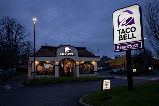 Tigard, OR, USA - Dec 23, 2021: Exterior view of a Taco Bell restaurant in Tigard, Oregon, in the evening. Taco Bell is an American-based chain of fast food restaurants owned by Yum! Brands, Inc.