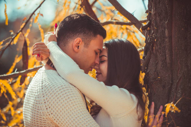 istock Pretty couple exchanges tenderness in the park 1361815253