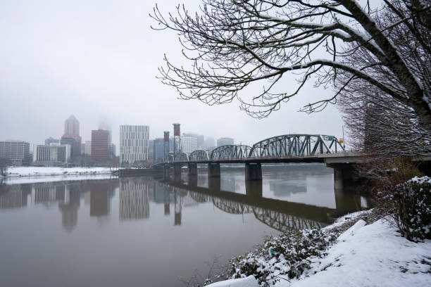 Portland, OR, USA - Dec 28, 2021: Hawthorne Bridge and downtown Portland skyline viewed from Eastbank Esplanade on a cold winter morning after snowfall.