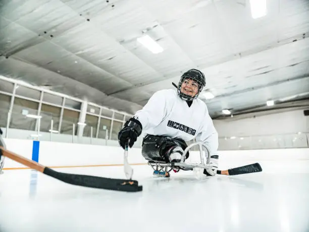 Photo of Mature Disabled Latin woman playing sledge hockey