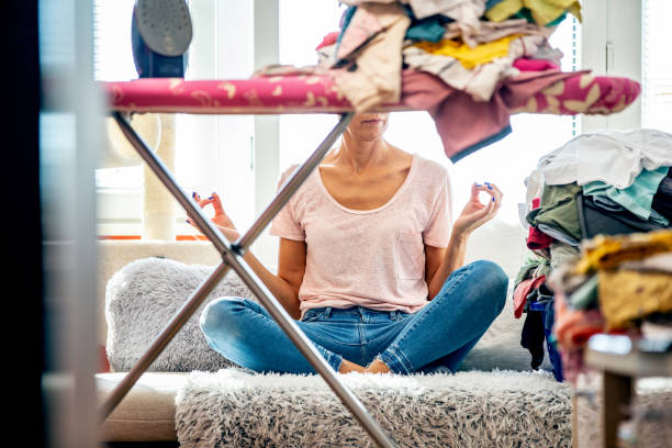 istock Woman meditating in Lotus position before starts ironing 1361817170