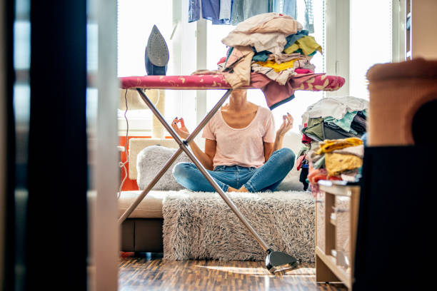 istock Woman meditating in Lotus position before starts ironing 1361817173