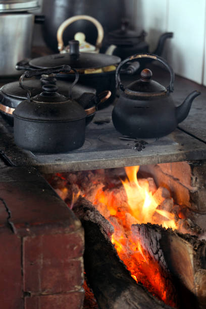 Iron pans over wood stove with highlighted flames. Brazilian culture