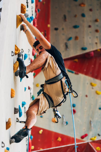 istock Young man exercising in climbing gym 1361821347