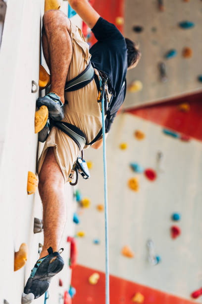 istock Young sporty man climbing up on practice mount wall outdoor 1361821349