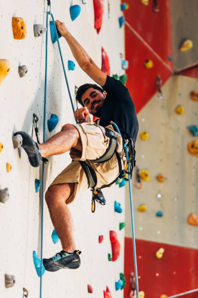 istock Muscular man practicing rock-climbing on a rock wall 1361821352
