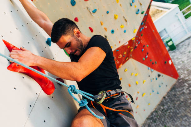 istock Sporty young man training in a colorful climbing gym 1361821377