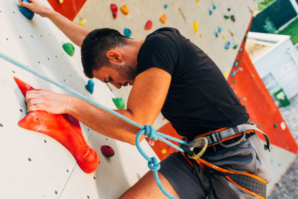 istock Muscular man climbing on a big wall 1361821379