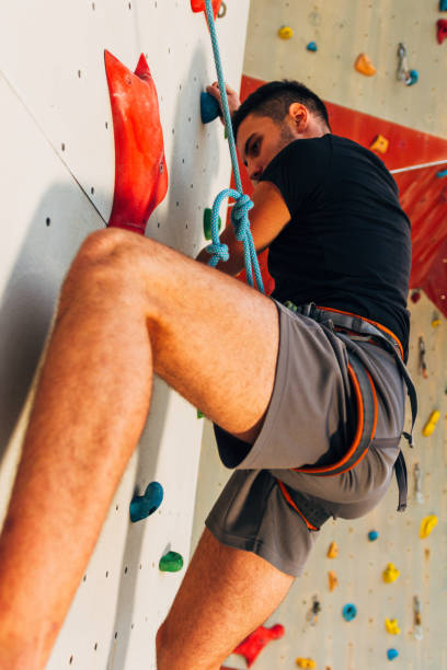 istock Man climbing wall with grips 1361821388