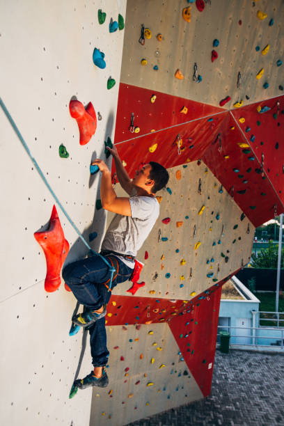 istock Young man exercising in climbing gym 1361821464
