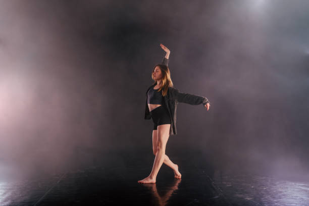 istock Shoeless female dance shows off her modern art dance moves while looking serious and devoted. 1361824157