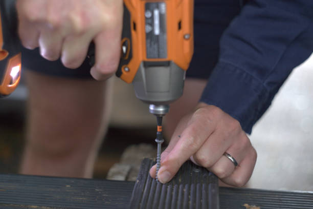 istock Man drilling a screw into black pine decking timber 1361824271